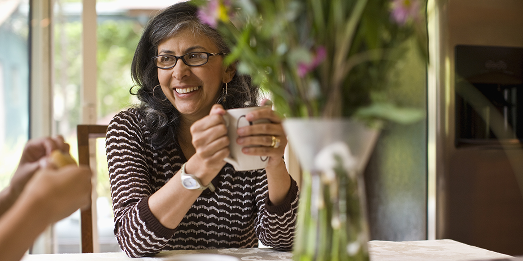 smiling woman holding coffee mug