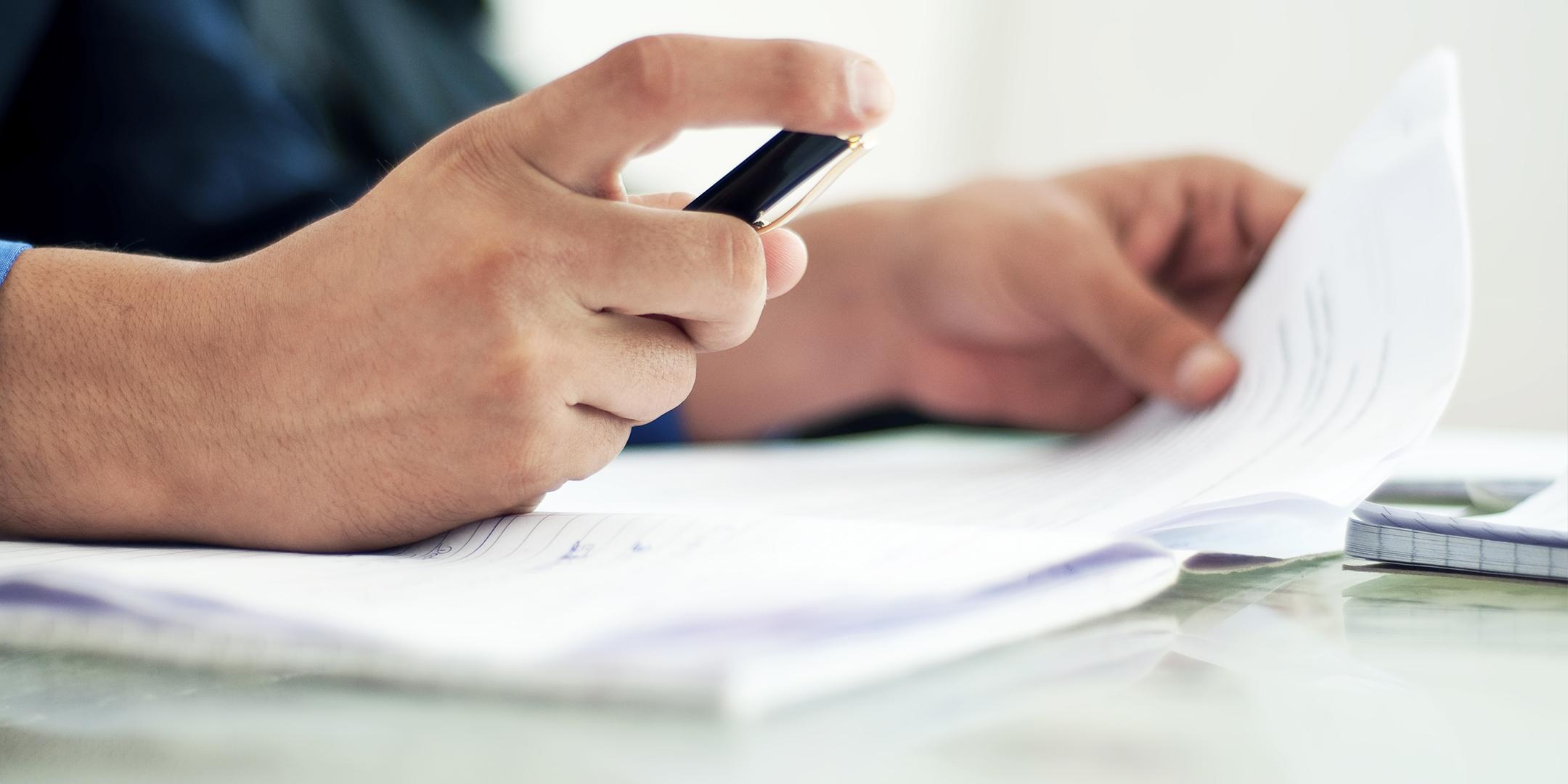 man with pen and note paper