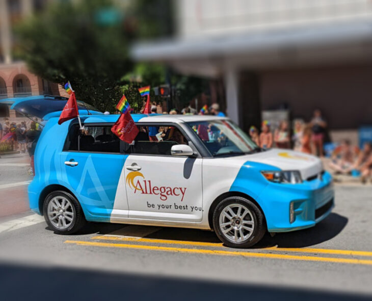 the Allegacy car on a downtown street during a pride parade