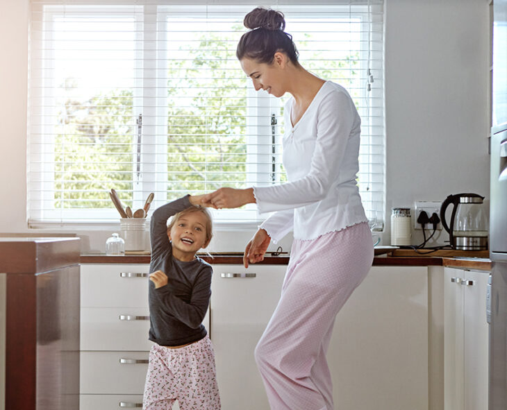 Mother and daughter enjoying some quality time at home dancing in the kitchen