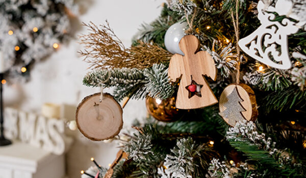 wood angel ornament hanging on a Christmas tree