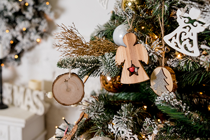 wood angel ornament hanging on a Christmas tree