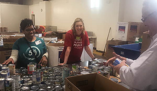 Volunteers in front of cans