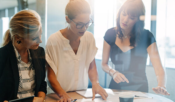 coworkers stand at an office desk