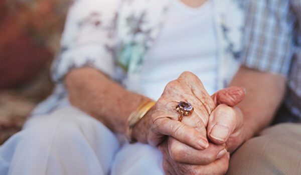 elderly couple holding hands