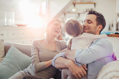 Family hugging on sofa