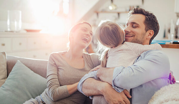 Family hugging on sofa