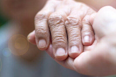 elderly hand in palm of caretaker