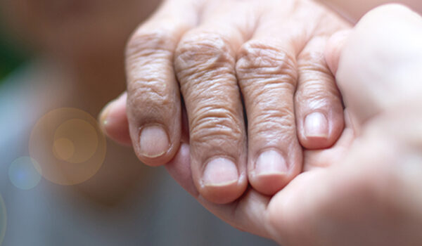 elderly hand in palm of caretaker