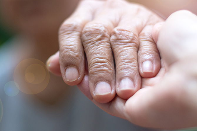 elderly hand in palm of caretaker