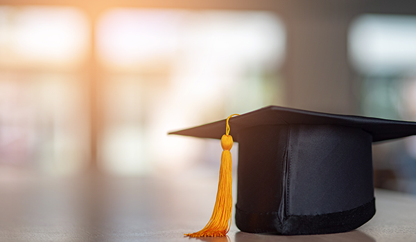 graduation gap with gold tassle in sunlit hallway