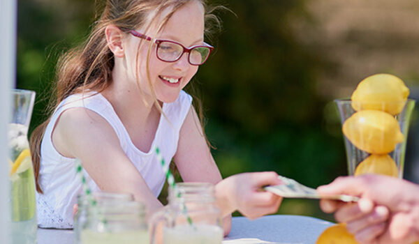 Girl taking money at lemonade stand