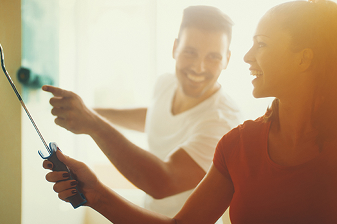 Couple painting at home and laughing benefits of a heloc applying for a heloc home equity investment strategies