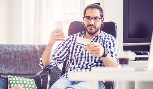 man using phone while holding a credit card