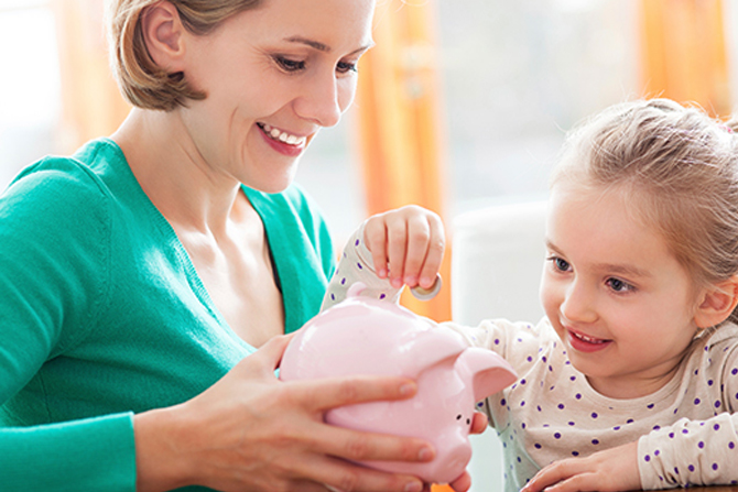 mother and daughter with piggy bank