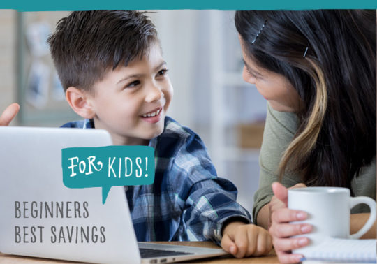 mom and son smiling at each other while son uses laptop
