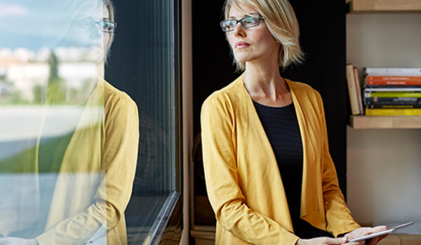 Woman in yellow jacket gazing out window