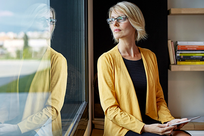 Woman in yellow jacket gazing out window
