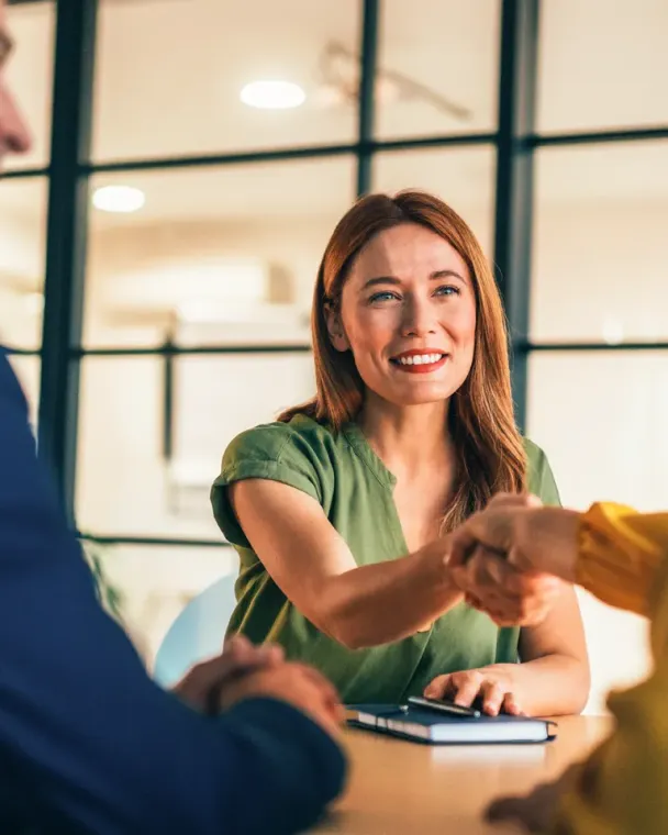 Woman shaking hands with a man and woman