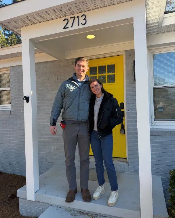 couple standing in front of their house