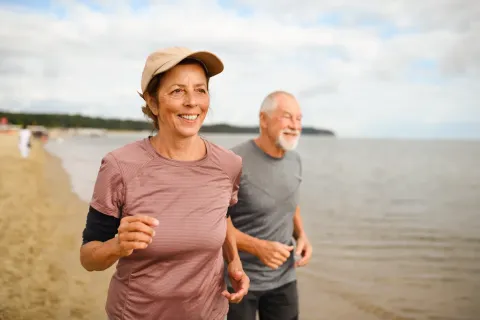 Older couple running along the beach